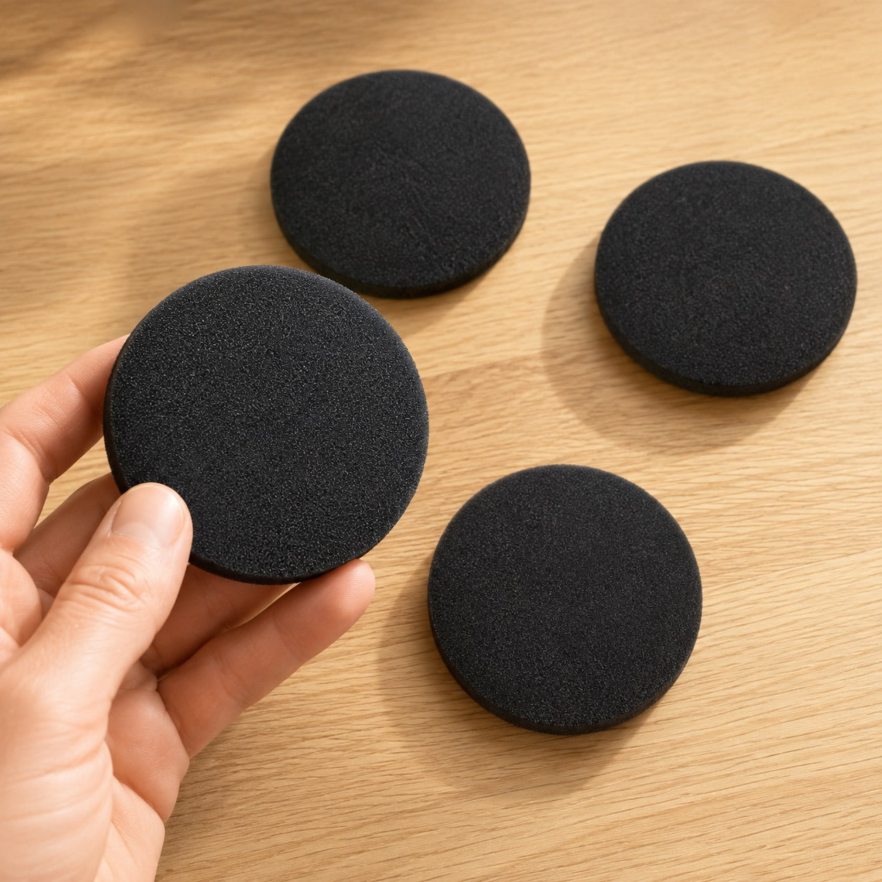 Hånd holder ett PelsVac skumfilter med tre ekstra filtre