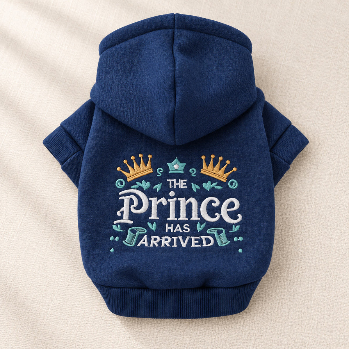Doghood hundegenser i marineblått med brodert Prince-motiv, lagt flatt på lin