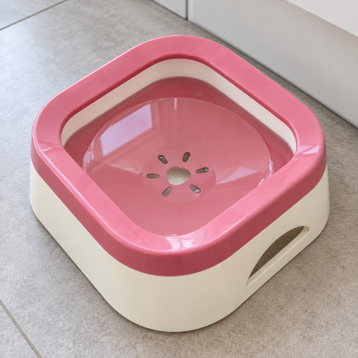 Rosa anti-søl drikkeskål sett ovenfra med flyteplaten som slipper vann bare i midten