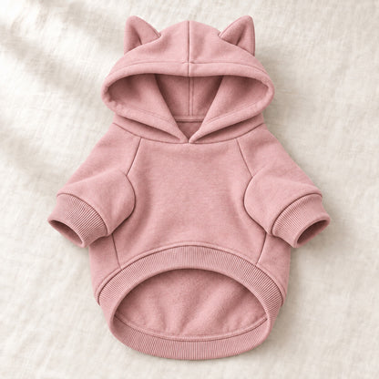Varmende hettegenser for hund i støvet rosa fleece, uten trykk, lagt flatt på lin
